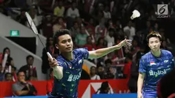 Pebulu tangkis, Tontowi Ahmad berusaha mengembalikan bola pukulan pasangan China, Zheng Siwei/Huang Yaqiong pada final Indonesia Masters 2018, Jakarta, Minggu (28/1). Owi/Butet kalah 21-14 dan 21-11. (Lipuatan6.com/Angga Yuniar)