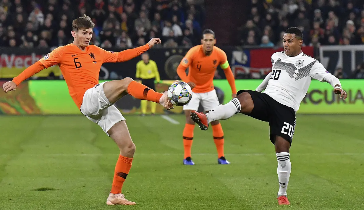 Pemain Belanda, Marten de Roon, berebut bola dengan pemain Jerman, Serge Gnabry, pada laga UEFA Nations League di Veltins Arena, Gelsenkirchen, Senin (19/11/2018). Kedua tim bermain imbang 2-2. (AP/Martin Meissner)