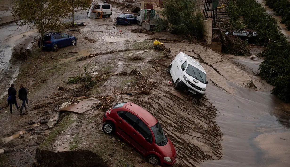 Mobil-mobil terperosok terbawa arus ke dalam tanah longsor terlihat di jalanan yang tergenang air di Alora, dekat Malaga, pada tanggal 30 Oktober 2024. (JORGE GUERRERO/AFP)