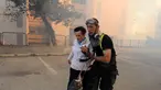 Petugas layanan darurat mengevakuasi seorang wanita dari rumahnya di kota utara Israel, Haifa, Kamis (24/11). Sekitar 80 ribu warga Israel diperintahkan untuk dievakuasi akibat kebakaran hutan yang melanda seluruh wilayah tersebut. (REUTERS/Rami Shlush)