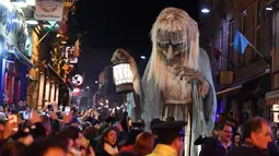 Sejumlah warga melihat nenek sihir raksasa saat menghadiri Parade Halloween di Irlandia (30/10). Parade ini untuk merayakan hari Halloween yang jatuh pada tanggal 31 Oktober. (REUTERS/Lucy Nicholson)