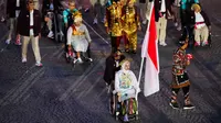 Atlet para-tenis meja Indonesia, Leli Marlina (kiri) dan atlet para-balap sepeda Indonesia, Muhammad Fadli Imammuddin terpilih sebagai pembawa bendera saat upacara pembukaan Pralimpiade Paris 2024 yang berlangsung di jalan raya ikonis Kota Paris, Place de la Concorde, Paris, Prancis, Rabu (28/08/2024) waktu setempat. (AFP/Dimitar Dilkoff)