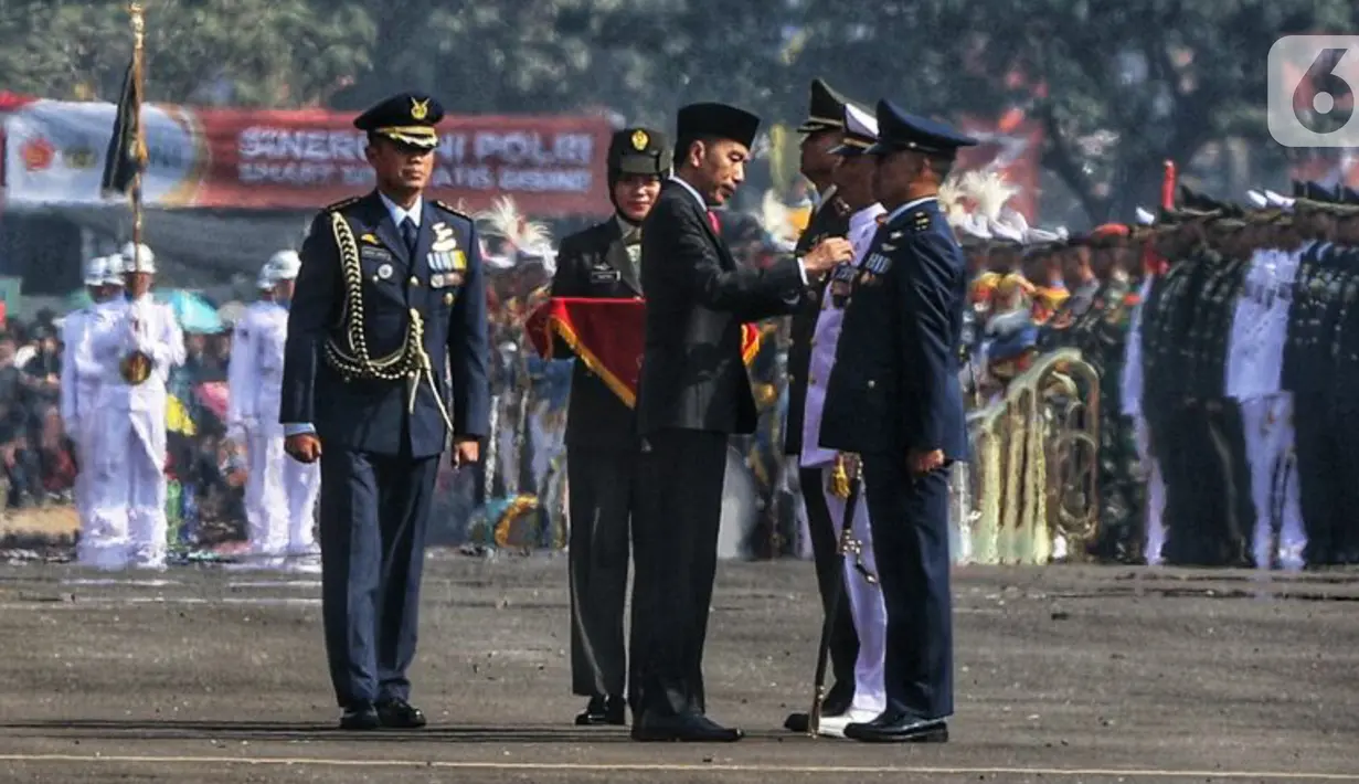 Presiden Joko Widodo atau Jokowi memberi penghargaan kepada prajurit pada perayaan HUT ke-74 TNI di Taxi Way Echo, Lanud Halim Perdanakusuma, Jakarta Timur, Sabtu (5/10/2019). Penghargaan tersebut merupakan lencana penghargaan tertinggi dari tiga matra di TNI. (Liputan6.com/JohanTallo)