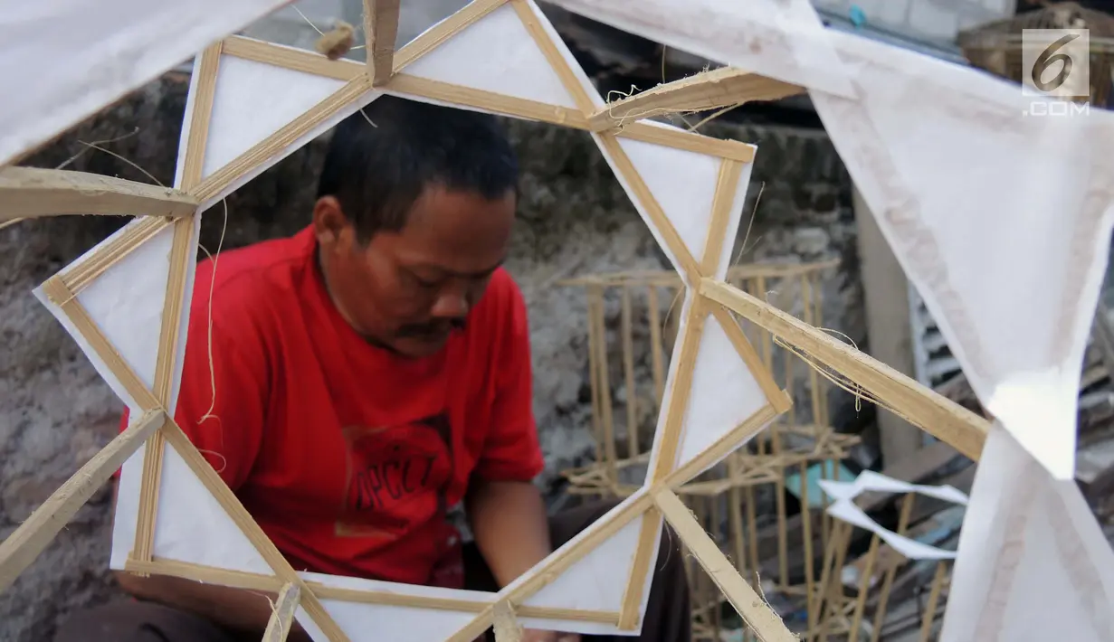Warga menyelesaikan pembuatan lampion dari bambu atau 'teng-tengan'di Kampung Perbalan, Kelurahan Purwosari, Semarang, Minggu (12/5/2019). Lampion  berbentuk persegi delapan yang terbuat dari bilah bambu dan kertas minyak putih itu diproduksi selama bulan Ramadan saja. (Liputan6.com/Gholib)
