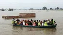 Relawan mengevakuasi warga desa yang terdampak banjir dengan perahu di Jalalpur Pirwala, distrik Multan, provinsi Punjab, pada 8 September 2025. (Shahid Saeed MIRZA/AFP)