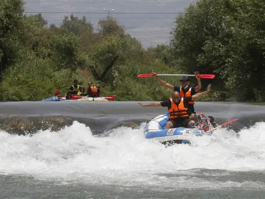 Umat muslim merayakan liburan Idul Fitri dengan rafting menyusuri Sungai Hasbani, Anak Sungai Yordan, di Kfar Blum, Israel, Rabu (27/5/2020). Pemerintah Israel mengurangi pembatasan aktivitas terkait pandemi virus corona COVID-19. (JALAA MAREY/AFP)