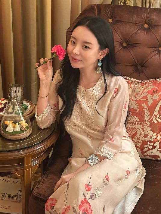 Dalam unggahan yang dibagikan pada Minggu, Jiwoo memamerkan kecantikannya dalam pakaian tradisional India, yakni salwar kameez berwarna putih floral dengan aksesoris khas seperti jhumka. Penampilan ini membuat penggemar, khususnya ARMY asal India, terpukau. Jiwoo berhasil membawa aura elegan sekaligus anggun dengan memadukan pakaian sederhana dan perhiasan tradisional. (Liputan6.com/IG/@mejiwoo103)