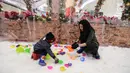 Ibu dan anak bermain salju dari es buatan di Lippo Mall Puri, Jakarta, Kamis (29/11). Wahana bermain Frosty Land di desain dengan suhu di bawah 0 derajat. (Liputan6.com/Fery Pradolo)