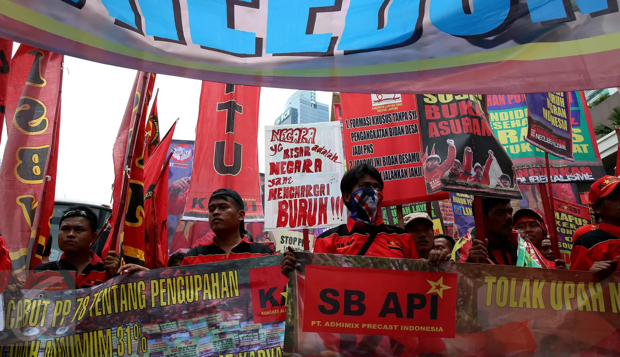 Ratusan buruh membawa spanduk saat melakukan aksi menuju Istana Negara, Jakarta (31/10). Buruh meminta pemerintah mencabut PP Nomor 78 soal pengupahan yang dinilai tidak memperhatikan kesejahteraan para buruh. (Liputan6.com/Johan Tallo)