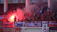 Suporter PSM Makassar menyalakan suar dalam partai perempatfinal Piala Presiden 2015 antara Mitra Kukar melawan PSM di Stadion Aji Imbut, Tenggarong, Sabtu (19/9/2015). (Bola.com/M. Ridwan)