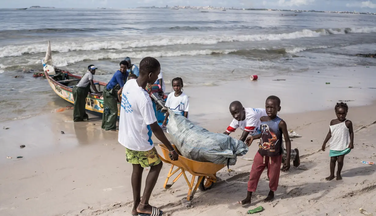 Anak-anak di lingkungan sekitar bergabung dengan relawan untuk membersihkan pantai di pinggiran Dakar, Senegal (13/9/2020). Relawan dan penduduk setempat berpartisipasi dalam kegiatan bersih-bersih pantai di Thiaroye-sur-Mer, sebuah kota kecil di pinggiran Dakar. (Xinhua/Louis Denga)