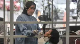 Calon penumpang melakukan tes antigen di Stasiun Pasar Senen, Jakarta, Senin (3/1/2022). PT KAI (Persero) menurunkan tarif tes antigen di stasiun bagi penumpang KA jarak jauh menjadi Rp35 ribu dari harga sebelumnya Rp45 ribu sebagai bentuk peningkatan pelayanan. (merdeka.com/Iqbal S. Nugroho)