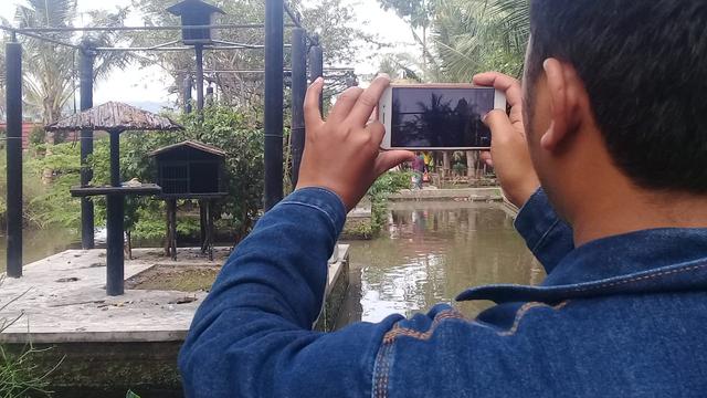Salah satu pengunjung taman satwa, nampak tengah mengambil gambar tingkah lucu taman satwa, saat liburan lebaran tahun ini