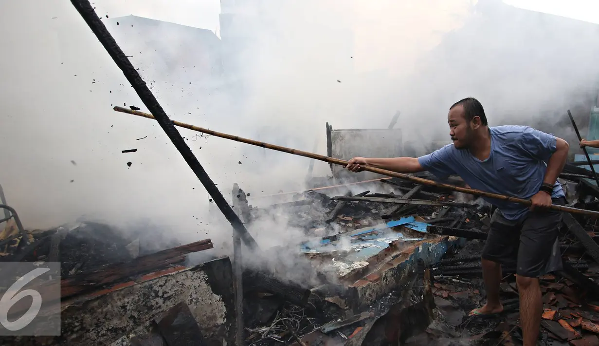 Warga membersihkan puing sisa kebakaran di kawasan Palmerah, Jakarta, Kamis (4/8). Api yang diduga berasal dari arus pendek itu membakar 8 rumah. (Liputan6.com/Immanuel Antonius)