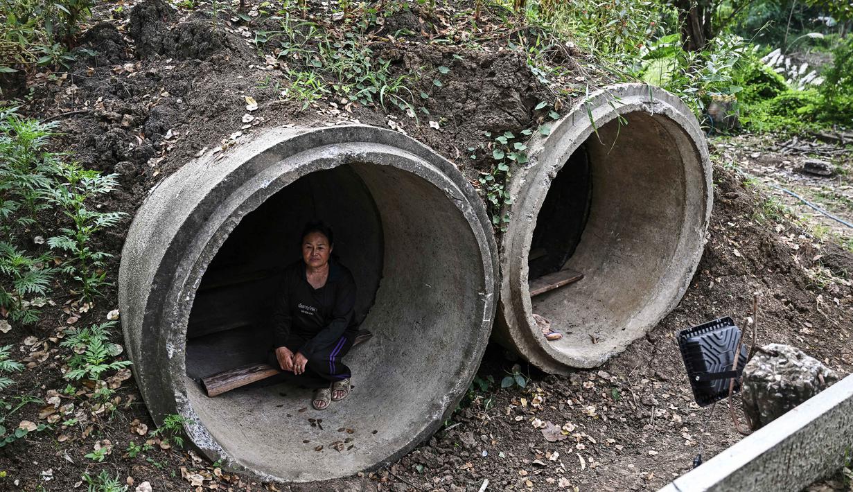 Petani Thailand, Pratuan Chuawong, duduk di dalam bunker dekat sebuah kuil selama bentrokan di sepanjang perbatasan Thailand-Kamboja di Provinsi Sa Kaeo, Thailand, pada Rabu 10 Desember 2025. Lebih dari 500.000 orang telah mengungsi ke tempat aman di Thailand dan Kamboja sejak dimulainya kembali konflik perbatasan. (Lillian SUWANRUMPHA/AFP)