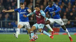 Pemain Burnley Dwight McNeil (tengah) berebut bola dengan pemain Everton Seamus Coleman (kiri) dan Abdoulaye Doucoure (kanan) pada pertandingan Liga Inggris di Goodison Park, Liverpool, Inggris, 13 September 2021. Everton menang 3-1. (Oli SCARFF/AFP)