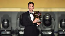 Pemain Barcelona, Lionel Messi memegang trofi setelah memenangkan pemain terbaik dunia FIFA Ballon d'Or 2015 di Kongresshaus, Zurich, Senin ( 11/1). Ini adalah kelima kalinya Messi meraih Ballon d'Or. (AFP PHOTO/FABRICE COFFRINI)