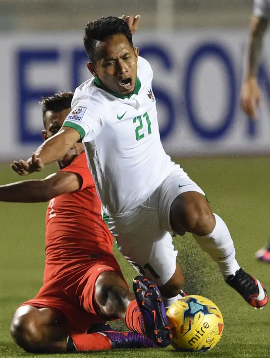 Andik Vermansyah dijegal Muhanna Shakir Hamzah saat Indonesia versus Singapura di Piala AFF 2016, Manila, Jumat (25/11). Andik menyumbang satu gol untuk kemenangan Indonesia dengan skor akhir 2-1. (AFP PHOTO / Ted Aljibe)
