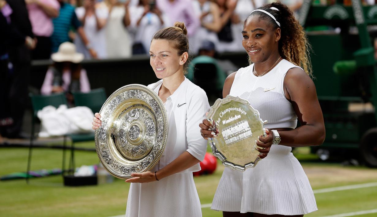 Petenis Simona Halep (kiri) bersama Serena Williams berpose dengan menunjukkan piala mereka usai bertanding dalam final tunggal putri Wimbledon 2019 di London, Inggris, Sabtu(13/7/2019). Petenis Rumania itu mengalahkan jagoan Amerika Serikat dua set langsung, 6-2 dan 6-2. (AP Photo/Tim Ireland)