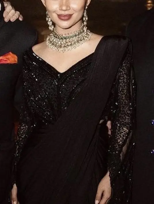 Ia pun melengkapi perhiasan dengan kalung mewah dan anting khas perempuan India. Dengan riasan natural bold yang mengaplikasikan lipstik maroon.  [@arieltatum]