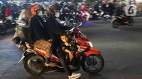 Pemudik yang menggunakan sepeda motor melintas di Jalan Raya Kalimalang, Bekasi, Jawa Barat, Rabu (19/4/2023) malam. (Liputan6.com/Herman Zakharia)
