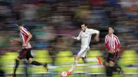 Aksi Gareth Bale saat menggiring bola melewati hadangan pemain Athletic Bilbao pada lanjutan La Liga di Santiago Bernabeu stadium, Madrid, senin (23/10/16) dini hari WIB. (AP/Daniel Ochoa de Olza)