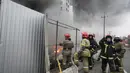 Petugas pemadam kebakaran berusaha memadamkan api di pusat logistik yang rusak setelah penembakan di Kiev, Ukraina, Kamis (3/3/2022). Rusia telah meluncurkan serangan jarak jauh ke Ukraina, menghantam kota dan pangkalan dengan serangan udara atau penembakan. (AP Photo/Efrem Lukatsky)
