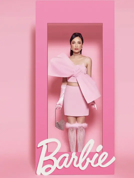 Artika tampil mengenakan two pieces warna pink dari fashion designer Devt. Two pieces terdiri dari atasan spaghetti strap memiliki detail pita besar dipadukan mini skirt, serta glove satin panjang. Lengkap dengan kaos kaki lace berbulu pink dan membawa mini bag lovenya. @dickyphotographie