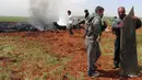Petugas memeriksa pesawat Su-22 milik Angkatan Udara Suriah yang ditembak jatuh di wilayah selatan Aleppo, Selasa (5/4). Sayap kelompok teroris Al-Qaeda di Suriah, Front al-Nusra, menembak jatuh jet SU-22 tersebut menggunakan roket. (OMAR HAJ KADOUR/AFP)
