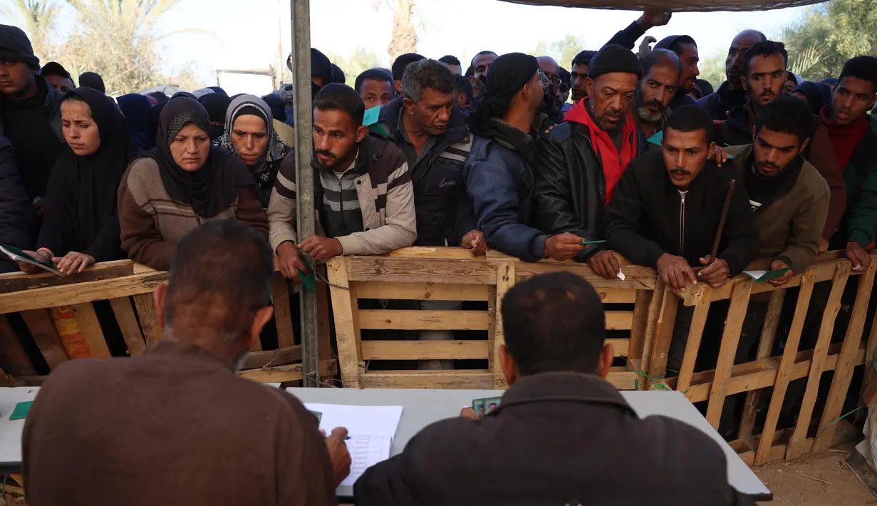 Warga Palestina menunggu giliran untuk menerima sekarung tepung bahan pangan di pusat distribusi di kota Khan Yunis, Jalur Gaza selatan, pada 3 Desember 2024. (BASHAR TALEB/AFP)