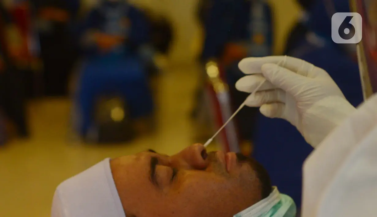 Calon jemaah umrah melakukan tes swab menjelang keberangkatan di Asrama Haji Pondok Gede, Jakarta, Selasa (11/1/2022). Hingga saat ini kurang lebih 1.000 jemaah telah diberangkatkan ke tanah suci Mekkah setelah dua tahun pandemi Covid-19. (merdeka.com/Imam Buhori)