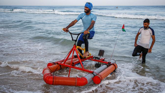 Nelayan Palestina menguji perahu kayuh yang dibuat khusus dari bahan daur ulang di sepanjang pantai di Beit Lahia, Jalur Gaza pada 29 September 2020. (Photo by MOHAMMED ABED / AFP)