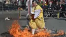 Ekspresi biksu Buddha saat berjalan di atas bara api atau yang dikenal sebagai “Nagatoro Hi-Matsuri,” di kuil Fudoji, kota Nagatoro, Jepang, Minggu (5/3). Mereka memanjatkan doa untuk kedamaian dunia dan keselamatan bagi semua orang. (Kazuhiro NOGI/AFP)