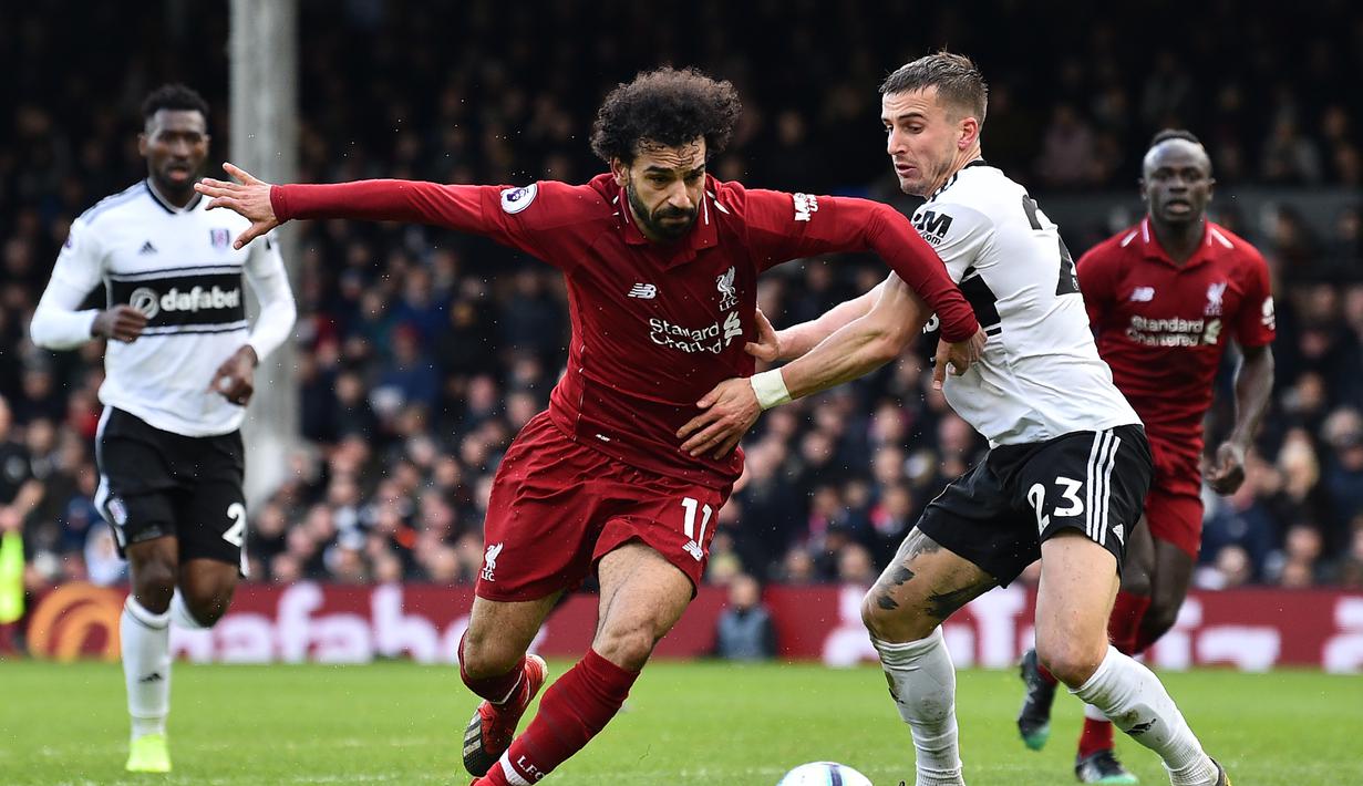 Aksi Mohamed Salah lewati gelandang Fulham, Joe Bryan pada laga lanjutan Premier League yang berlangsung di Stadion Craven Cottage, London, Minggu (17/3). Liverpool menang 2-1 atas Fulham. (AFP/Glyn Kirk)