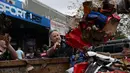Para relawan membantu penduduk setempat untuk membersihkan barang-barang yang rusak akibat banjir dari toko-toko mereka di sepanjang tepi Sungai Manning di Taree pada tanggal 23 Mei 2025. (Saeed KHAN/AFP)
