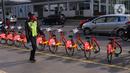 Petugas keamanan melintas di dekat deretan sepeda untuk layanan bike sharing atau penyewaan sepeda di Kawasan Jakarta, Jumat (3/7/2020). Layanan bike sharing yang bertujuan untuk mengurangi penggunaan kendaraan bermotor ini terbagi dalam 6 titik lokasi di Jakarta. (Liputan6.com/Angga Yuniar)