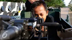 Anak-anak tampak senang memainkan senjata ketika menaiki Panser Anoa dalam pameran road to campus Alat Utama Sistem Persenjataan (Alutsista) di kawasan Boulevard Universitas Indonesia, Depok, Jawa Barat, Kamis (27/8/2015). (Liputan6.com/Yoppy Renato)