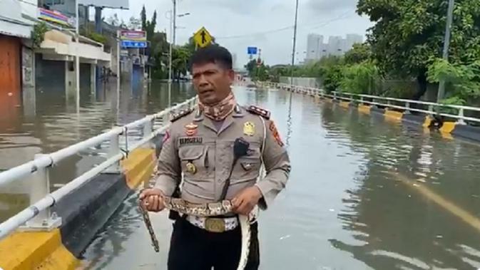 Seorang polisi melaporkan situasi banjir sambil memegang ular yang ia temukan menjadi viral di Twitter.
