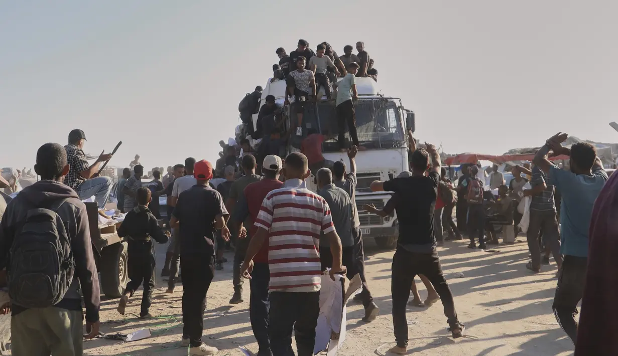 Warga Palestina mencegat dan menyerbu truk yang membawa bantuan kemanusiaan di sepanjang koridor Morag dekat Rafah, Jalur Gaza selatan, Senin, 4 Agustus 2025. (AP Photo/Mariam Dagga)