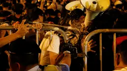 Pengunjuk rasa disemprot cairan merica oleh petugas saat demonstrasi yang berujung kericuhan di Hong Kong, Minggu (6/10). Kericuhan terjadi setelah massa terlibat deadlock selama delapan jam dengan aparat keamanan yang menjaga lokasi. (REUTERS/Tyrone Siu)