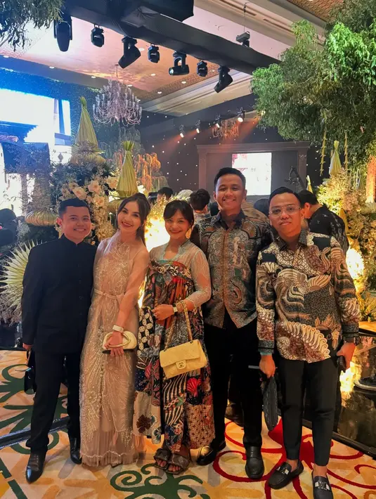 Makeup natural dengan sentuhan bibir merah cerah dan rambut berponi yang dibiarkan tergerai, menambah kesan segar dan effortless chic. [@amelcarla].