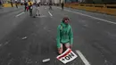 Seorang demonstran beristirahat dengan membawa poster bertuliskan "No more dictatorship," selama unjuk rasa di Caracas, Venezuela, (6/4). (AP Photo / Fernando Llano)