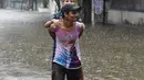 Seorang pria menggendong keluarganya melintasi banjir setelah hujan lebat di Mumbai, India (9/7). Departemen Meteorologi India mengeluarkan peringatan banjir akibat hujan deras di tempat-tempat terpencil di wilayah tersebut. (AFP Photo/Indranil Mukherjee)