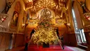 Dekorator menghias pohon cemara besar dari Windsor Great Park di ujung aula St. George di Windsor Castle, Inggris, 30 November 2018. Pohon setinggi 6 meter itu dihias dengan pernak-pernik Natal berwarna emas serta ornamen kerajaan.  (AP/Frank Augstein)