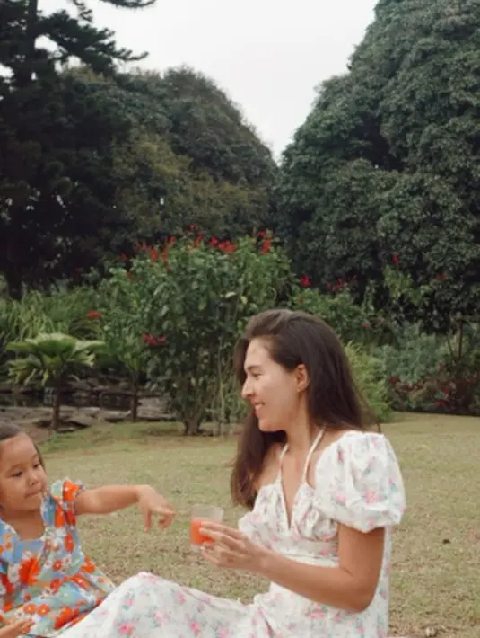Santai di sebuah taman, begini momen Olivia Jensen dan sang anak saat piknik istirahat dari kegiatan berkebun. Keduanya tampil cantik pakai dress bermotif floral.(instagram.com/oliviajensen)