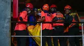 Sejumlah petugas mengangkat kantong berisi jenazah korban kebakaran KM Mutiara Sentosa II setibanya di Dermaga Jamrud Utara, Pelabuhan Tanjung Perak, Surabaya, Jawa Timur, Senin (3/8/2026).  (AFP/ Juni Kriswanto)