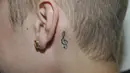 Tato di balik telinga kiri Justin Bieber berbentuk simbol stradivarius. (Bintang/EPA)