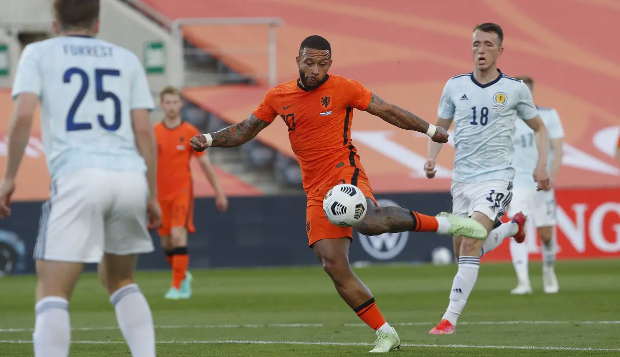 Kesalahan Bek Skotlandia ketika membuang bola, dimanfaatkan oleh Memphis Depay dengan tendangan voli kerasnya ke sudut bawah gawang dan gol. Belanda berhasil menyamakan kedudukan (1-1) menit ke-17. (Foto: AP/Miguel Morenatti)