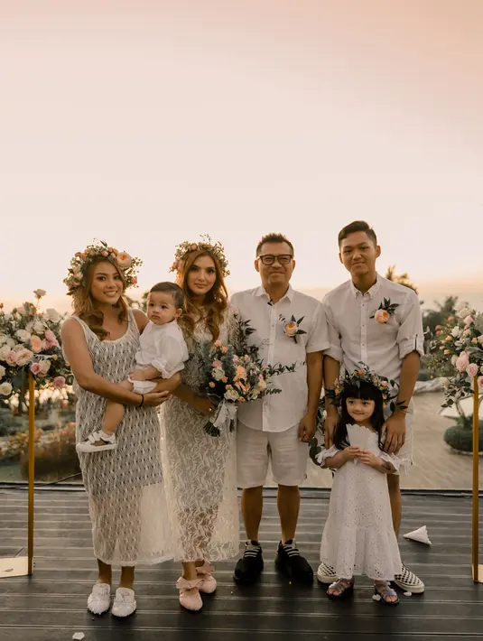 Saat merayakan ulang tahun pernikahan, keluarga ini tampil kompak dengan mengenakan busana warna putih yang dipadu dengan bunga-bunga. (Foto: instagram.com/ashanty_ash)