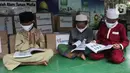 Anak-anak membaca buku cerita dan pelajaran pada aksi Peduli Pendidikan di Sekolah Alam Bantar Gebang, Bekasi, Jumat (5/3/2021). Sebanyak 500 buku pelajaran dan 300 paket kesehatan berupa masker dan multivitamin senilai Rp 25 juta didonasikan dalam mendukung dunia pendidikan. (Liputan6.com/HO/Iqbal)